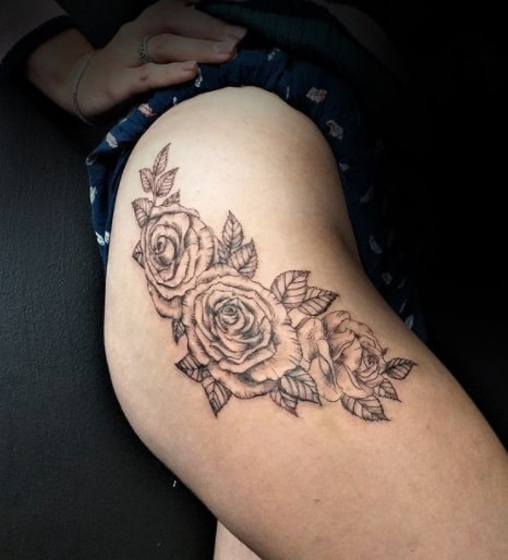 flowers on thigh black ink tattoo