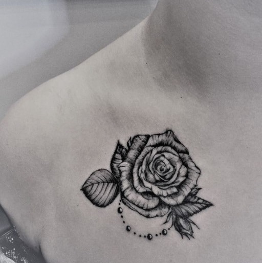 rose on the chest black ink tattoo