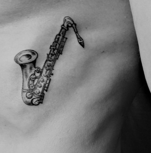 saxophone on ribs black ink tattoo
