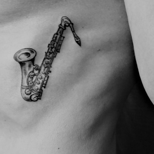saxophone tattoo on ribs for man 